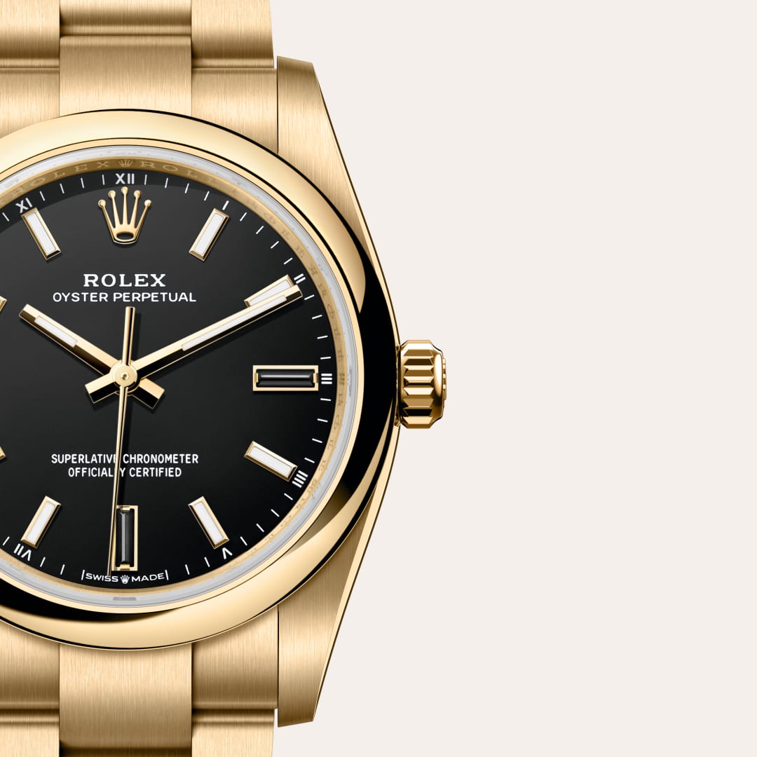 Rolex Oyster Perpetual 34 in 18 ct yellow gold with a black dial, domed bezel, and Oyster bracelet.