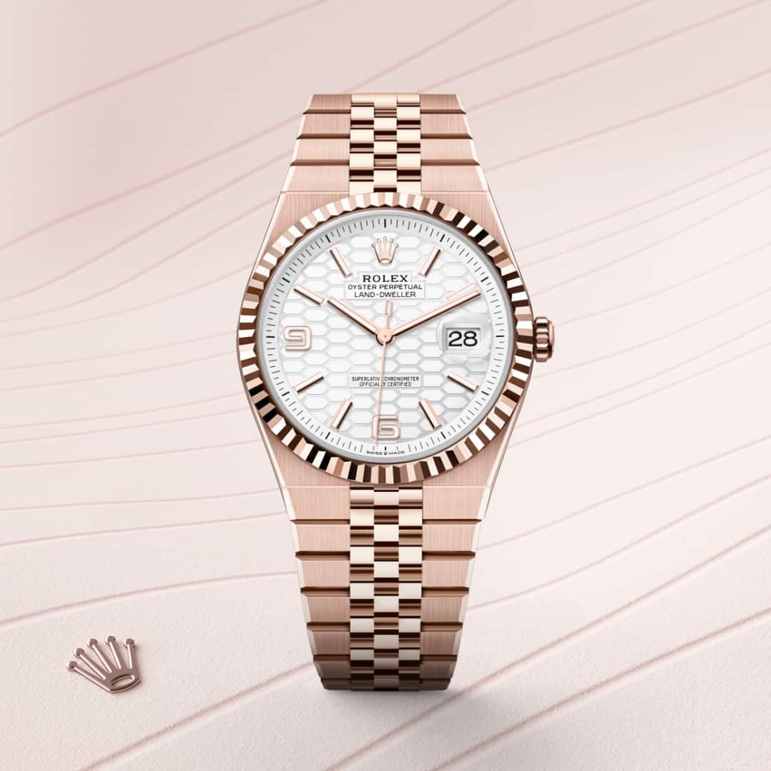 Rolex Land-Dweller 40 in 18 kt Everose gold with a intense white, honeycomb motif dial, fluted bezel, and Flat Jubilee bracelet.