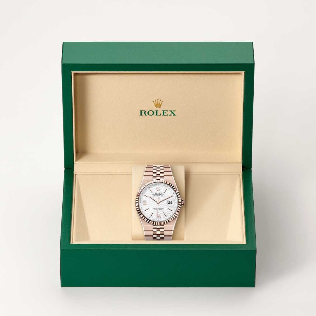 Rolex Land-Dweller 40 in 18 kt Everose gold with a intense white, honeycomb motif dial, fluted bezel, and Flat Jubilee bracelet.