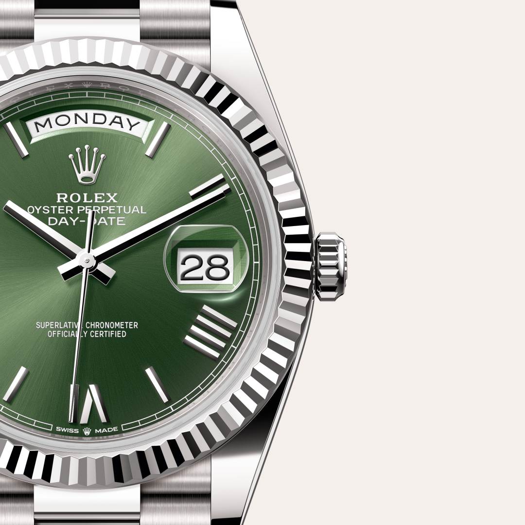 Rolex Day-Date 40 in 18 kt white gold with a olive green dial, fluted bezel, and President bracelet.
