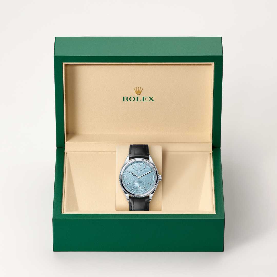 Rolex 1908 in Platinum with a ice blue, rice-grain motif dial, domed and fluted bezel, and Leather strap bracelet.