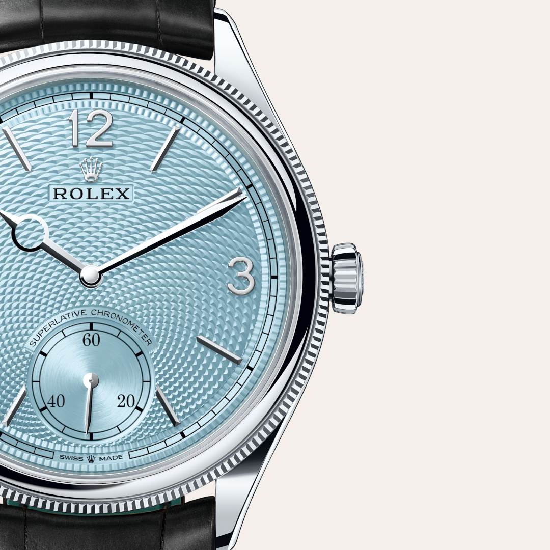 Rolex 1908 in Platinum with a ice blue, rice-grain motif dial, domed and fluted bezel, and Leather strap bracelet.